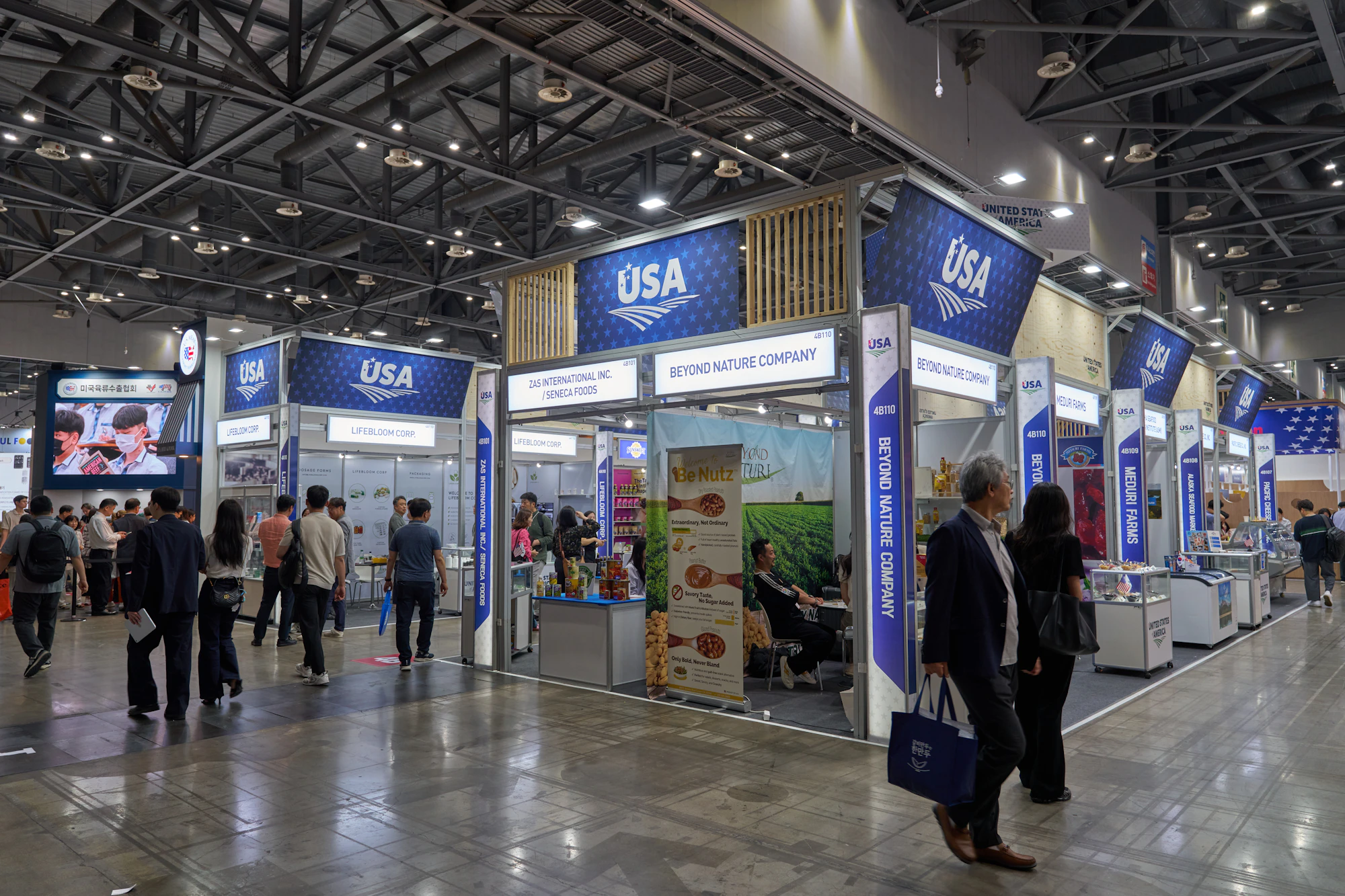 Visitors walking through an exhibition with printed booth graphics - event photography