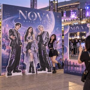 Concert photo zone with artist standees, album concept backdrop and oversized photocard frame